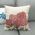 Dettaglio della federa in lino con motivo a rose su un divano in tessuto grigio - 45x45cm / Rosa Viola Rosa
