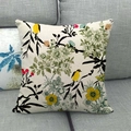Detail of floral and bird print on linen cushion cover showing fabric texture on a sofa - Chinese Yellow Birds and White Chrysanthemums (5)