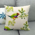 Linen cushion cover featuring watercolor bird and leaf print on a gray sofa - Watercolor Goldfinch and Green Leaves (7)