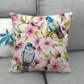 Detail of linen cushion cover featuring blue birds and pink cherry blossoms on a sofa - Blue Bird and Pink Cherry Blossoms (18)