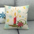 Detail of linen Christmas pillowcase with candle and poinsettia print on grey sofa - Red Candle Style
