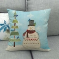 Close-up of rustic snowman Christmas cushion cover on a grey sofa with holiday greetings - Snowman And Patchwork Tree Decor Style