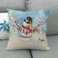 Close-up of linen Christmas pillowcase with snowman design on a grey fabric sofa - Merry Christmas Snowman Blessing Style