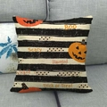 Detail of Halloween pumpkin throw pillow with Boo text on a grey fabric sofa - Stripe Background Pumpkin Slogan (5)