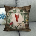 Gros plan sur le texte JOY rustique d'un coussin de Noël en lin avec couronne de sapin - Style 19