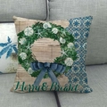 Détail de la housse de coussin de Noël en lin avec couronne marine sur un canapé - Merry Bright Couronne d'Océan (2)