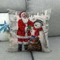 Funda de cojín navideña de lino con Papá Noel y muñeco de nieve en un sofá gris - Entrega de Regalos Retro en la Nieve (4)