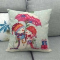 Linen Christmas pillowcase featuring cartoon snowmen under an umbrella on a grey sofa - Snowmen under Pink Umbrella