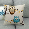 Close-up of linen pillowcase featuring cartoon owl embroidery on a grey fabric sofa - Two Owls with Yellow Flowers (11)