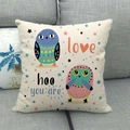 Cream linen pillow cover featuring blue and pink cartoon owls on a gray sofa - Two Owls with Stars (17)