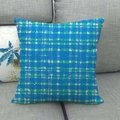 Detail eines blau-grünen Kissenbezugs mit geometrischem Karomuster auf Sofa - Dunkelblaues und grünes Gitter