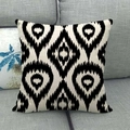 Détail de la housse de coussin en lin avec motifs ikat noirs et blancs sur un canapé gris - 12