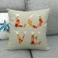 Funda de cojín decorativa de lino con letras LOVE florales sobre sofá de color verde claro - Verde Salvia(4)
