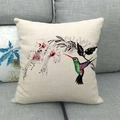 Detailansicht eines Leinenkissenbezugs mit Kolibri- und Blumenprint auf grauem Sofa - Kolibri und Rote Blume Stil (4)