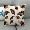 Housse de coussin en lin avec motif papillon orange sur un canapé gris - Papillon Monarque (6) / 45x45 cm
