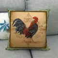 Detail view of vintage rooster cushion cover with colorful patterns on a grey sofa - Multicolor Rooster Green Geometric Border / 18x18 Inch