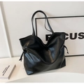 Detail of glossy black leather tote bag featuring adjustable side drawstrings and slim straps - Black