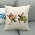 Detail of square linen pillow with watercolor sea turtle print on a grey fabric sofa - Red Green Double Turtle Bubbles (13)