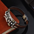 Pulsera de dragón de cuero retro con dijes vintage sobre cuaderno de cuero - Marrón
