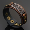 Macro view of wide brown leather bracelet with Celtic knot metal plate and snap button - Brown