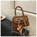Vue détaillée d'un mini sac carré marron avec un nœud en strass et une chaîne en métal - Marron