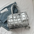 Detailed macro view of silver quilted tote bag with padded handles and adjustable strap - Silver