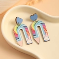 Detail von Regenbogen-Bleistift-Holzohrringen auf einem dekorativen Herztablett - Regenbogen-Stil
