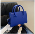 Detail einer blauen quadratischen Umhängetasche mit goldener Hardware und Rundgriff - Blau
