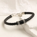 Detalle de pulsera de cuero trenzado negro con tubo de metal plateado y cierre de langosta - Diseño de Tubo de Metal Liso