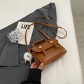 Retro brown leather crossbody bag with flap and decorative straps on a grey blazer - With Pendant / Brown