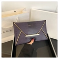 Detail of dark purple crocodile texture envelope clutch with gold metal trim and flap - Purple