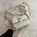 Elegant white quilted crossbody bag with gold buckle on a beige blazer background - White
