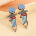 Holzohrringe mit Bleistift- und Doktortitel-Motiv auf einem Keramiktablett serviert - Doktorhut & Bleistift