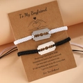 Detail of woven rope couple bracelets with stainless steel blade charms on gift card - Black and White Set (Black + White)