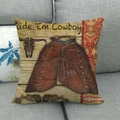 Linen pillowcase with vintage cowboy print and Ride Em Cowboy text on gray sofa - Wood Grain Chaps & Bull Head Style (10)