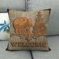 Detail eines Vintage-Leinenkissenbezugs mit Holzmaserung und Schwarzbär-Willkommensmotiv - 45x45 cm / Bär und Kiefern Welcome (4)