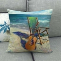 Dettaglio della federa in lino con scena di spiaggia e chitarra su un divano grigio - Stampa Chitarra In Spiaggia E Vista Mare (19)