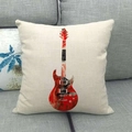 Primer plano de funda de cojín de lino con estampado de guitarra sobre sofá gris - Estilo Guitarra Abstracta Rojo y Negro