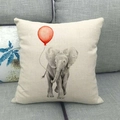 Close-up of linen cushion cover showing elephant with red balloon print on a grey sofa - Grey Elephant with Red Balloon (7)
