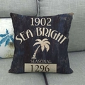 Vintage navy linen pillow case with seaside graphic print on a grey textured sofa - Sea Bright Retro Navy Palm Style (8)