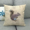Cuscino decorativo in lino con scoiattolo e stampa vintage posizionato sul divano - Motivo Scoiattolo