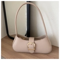 Detalle de bolso baguette de cuero sintético beige con hebilla dorada sobre madera - Caqui