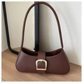 Detalle de bolso baguette en cuero marrón con hebilla trapezoidal de metal dorado - Marrón
