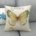 Linnen kussenhoes met gele vlinderprint en GREEN-tekst op een grijze stoffen bank - 45x45 cm / Geel-Groene Retro Vlinder (4)
