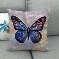 Funda de cojín cuadrada de lino con mariposa azul y violeta sobre un sofá gris - Mariposa de Ensueño Azul Púrpura (4)