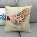 Detail of linen pillow cover with floral rooster print on a gray fabric sofa - Beige Pink Rose Rooster (4)