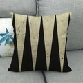 Gros plan d'un coussin en lin avec motifs géométriques triangles noirs et beige sur canapé - Triangles Mouchetés Rétro (5)