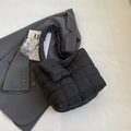 Bolso tote acolchado negro con bolsa pequeña sobre fondo de blazer gris elegante - Negro