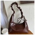 Detail der dunkelbraunen Hobo-Tasche mit gerafftem Trageriemen und Schleifendekoration - Braun