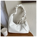 Detail of white minimalist shoulder bag featuring scrunchie handle and leather texture - White